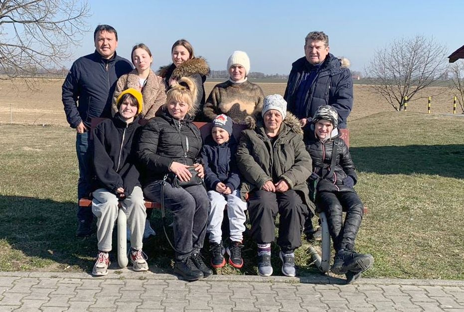 Javier Colino y David de la Riva posan junto a las familias a las que rescataron un año atrás. Ahora tienen una ONG de ayuda a Ucrania y aquellos refugiados han vuelto a Leópolis.