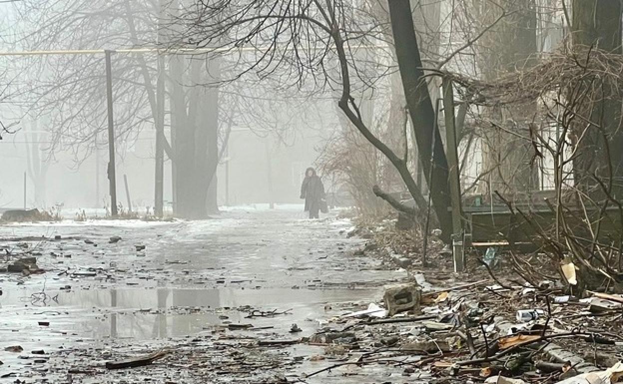 Una vecina camina entre la niebla por una calle encharcada y ruinosa de Chasiv Yar, en la misma línea del frente que divide a las tropas ucranianas y rusas.