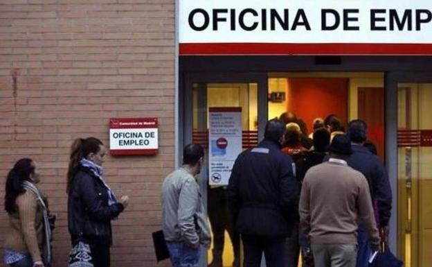 Personas haciendo cola a las puertas de una oficina de empleo.