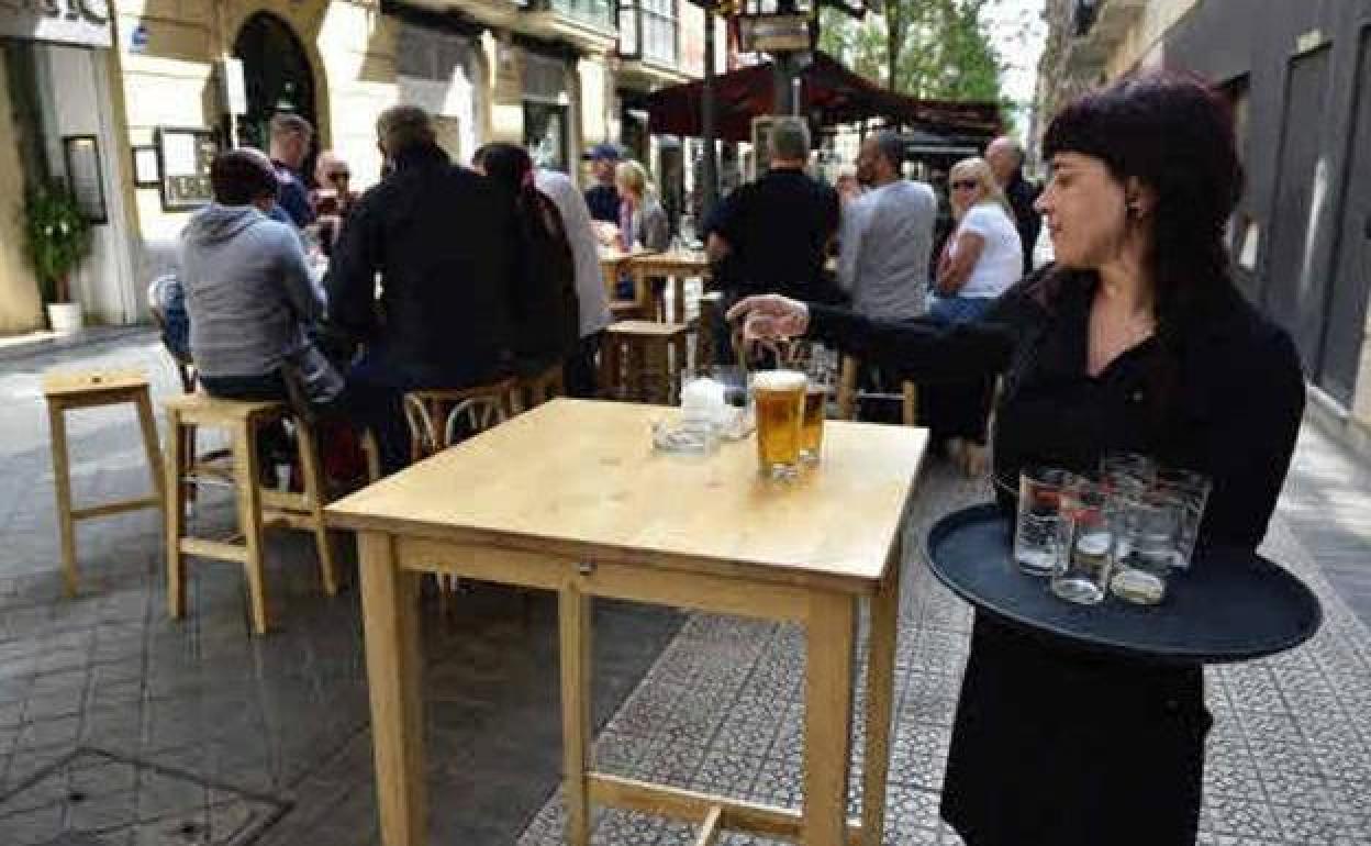 Una camarera sirviendo en una terraza.