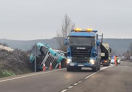 El camión accidentado en Boñar, esta mañana, mientras la Guardia Civil trabaja para retirarlo.