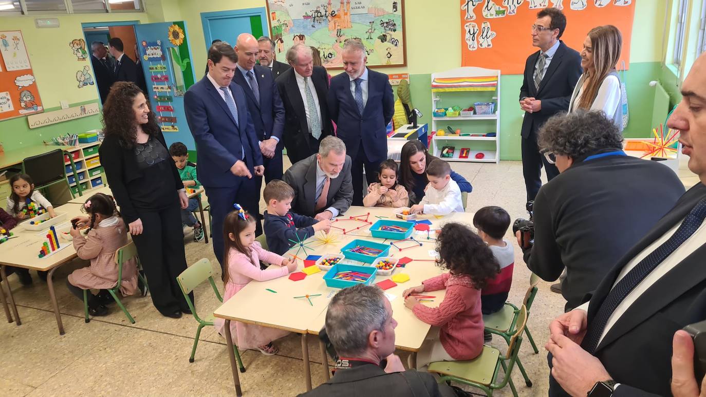 Felipe VI y Letizia saludan y charlan con algunos de los alumnos del centro premiado en su visita a las instalaciones del colegio.