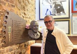 El periodista Carlos Herrera junto a su busto en el Camarote Madrid.