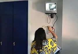 Una mujer introduce dinero para poder ver la televisión en una habitación del hospital.