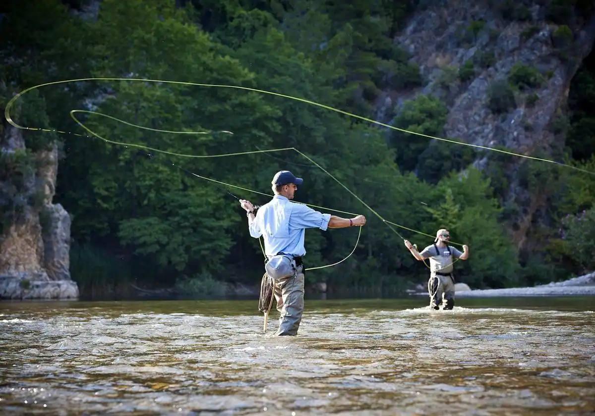 Varios pescadores en las aguas de un río leonés.