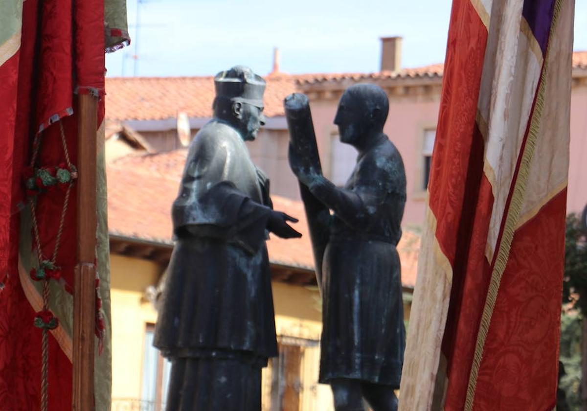 Escultura que representa al abad emérito de San Isidoro Antonio Viñayo que recibe el cirio de manos del síndico municipal.