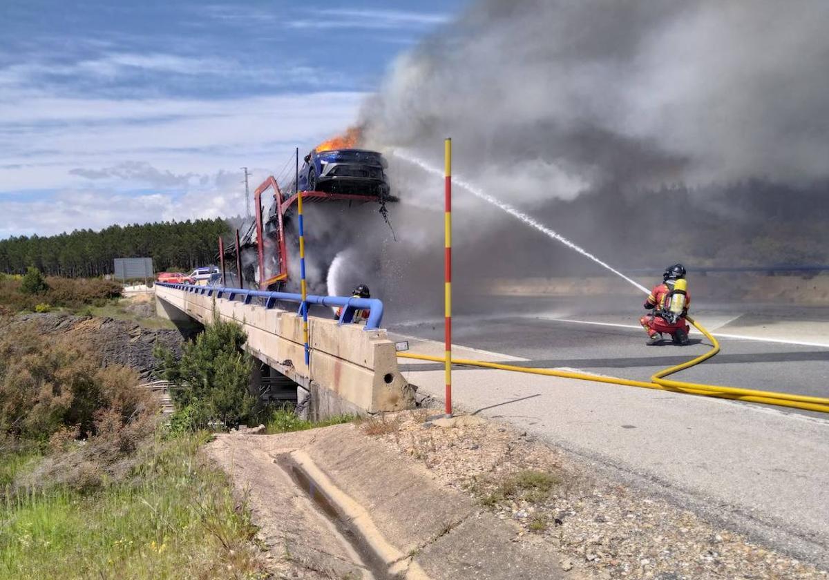 Los bomberos sofocan el fuego en el camión porta-vehículos en la A-6 a la altura de Villagatón.