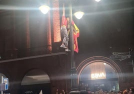 Un joven trepando por una farola en la fiesta.