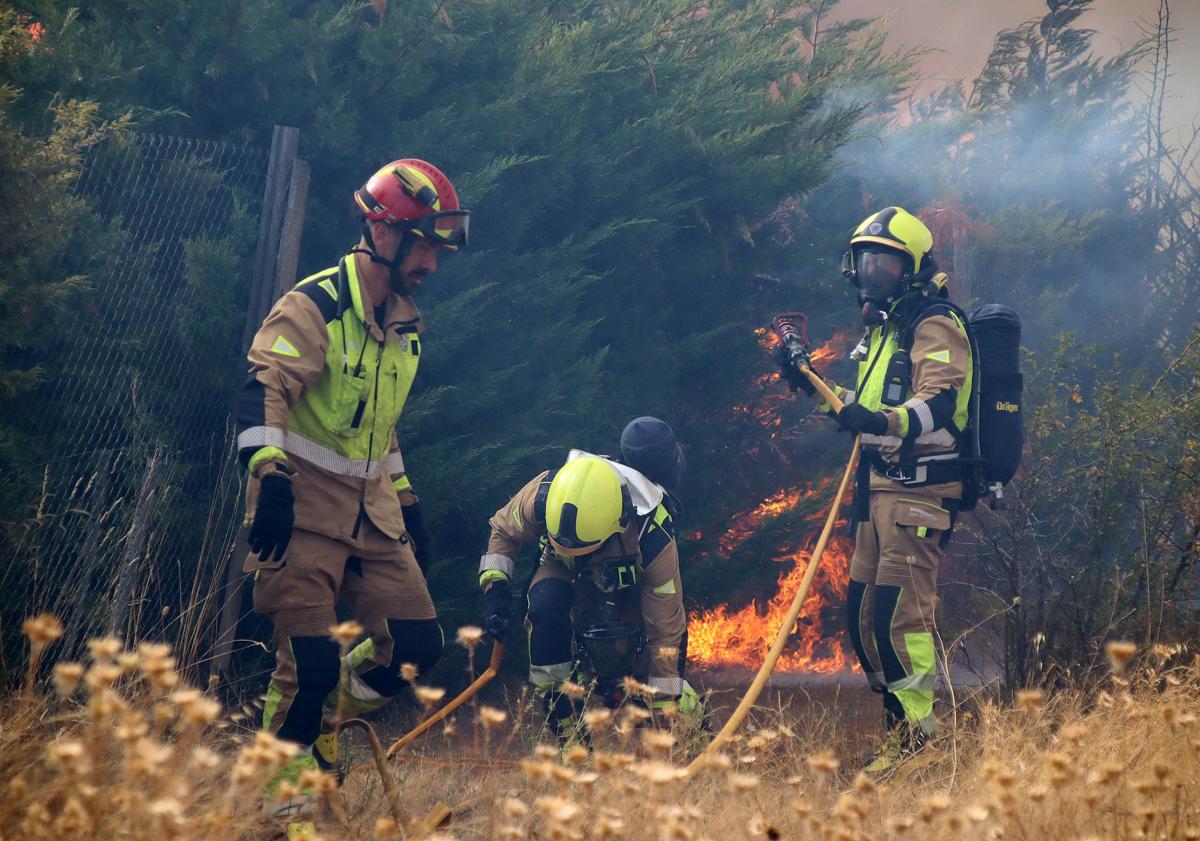 Imagen principal - Los bomberos trabajan en apagar las llamas.