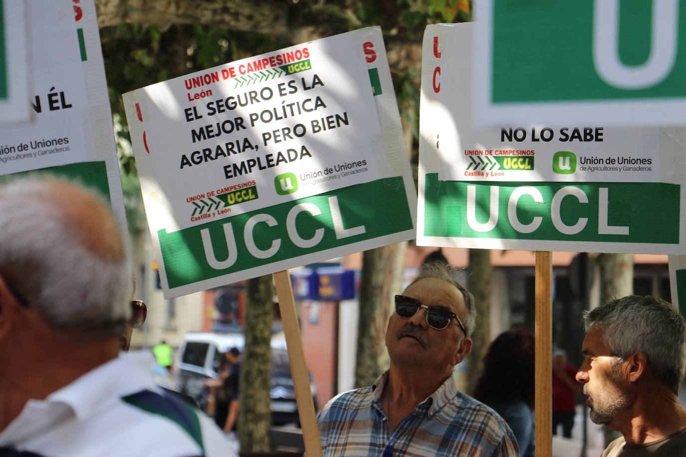 Un señor levanta un cartel que reza por la necesidad de tener un seguro agrario.