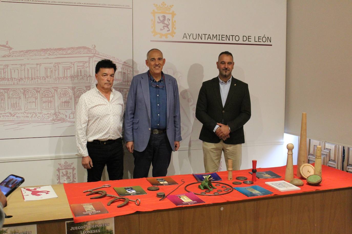 Emilio Fernández, Vicente Canuria y Emilio Martínez posan junto a elementos típicos de juegos tradicionales leoneses.