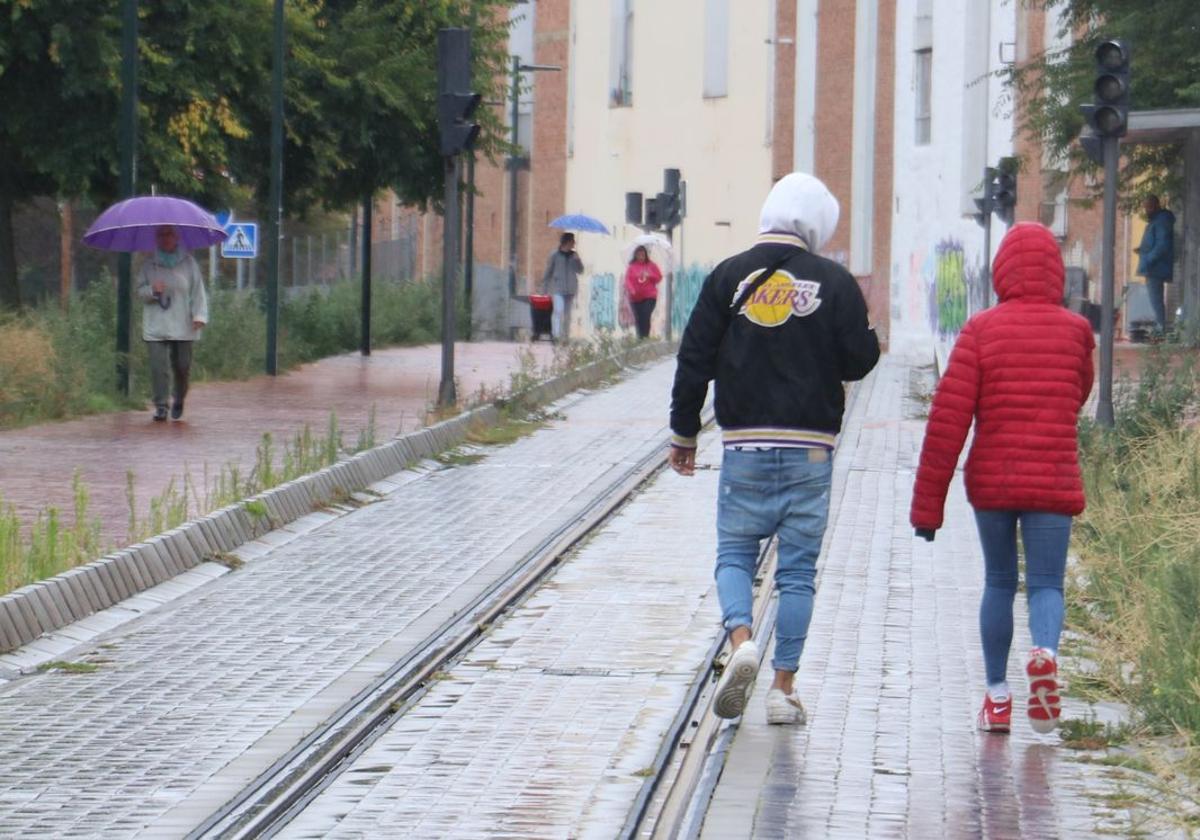 Dos personas caminan por las vías del tren que nunca han sido utilizadas.