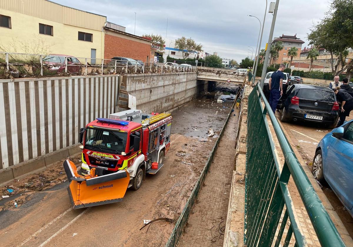 Imagen principal - Bomberos de León trabajan en garajes de Valencia anegados tras la DANA