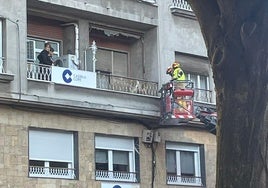 Bomberos accediendo a la vivienda con un vehículo autoescalera.