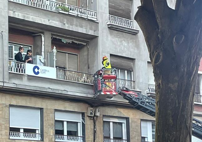 Bomberos accediendo a la vivienda con un vehículo autoescalera.