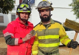 Un bombero forestal de la Brif de Tabuyo junto a una valenciana en un pueblo afectado por la DANA.