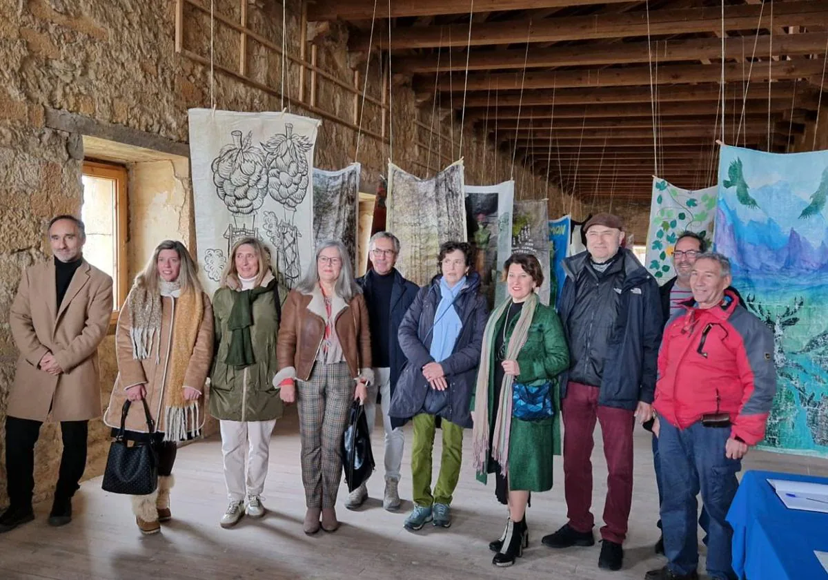 Algunos de los artistas junto a las obras en el claustro del monasterio.