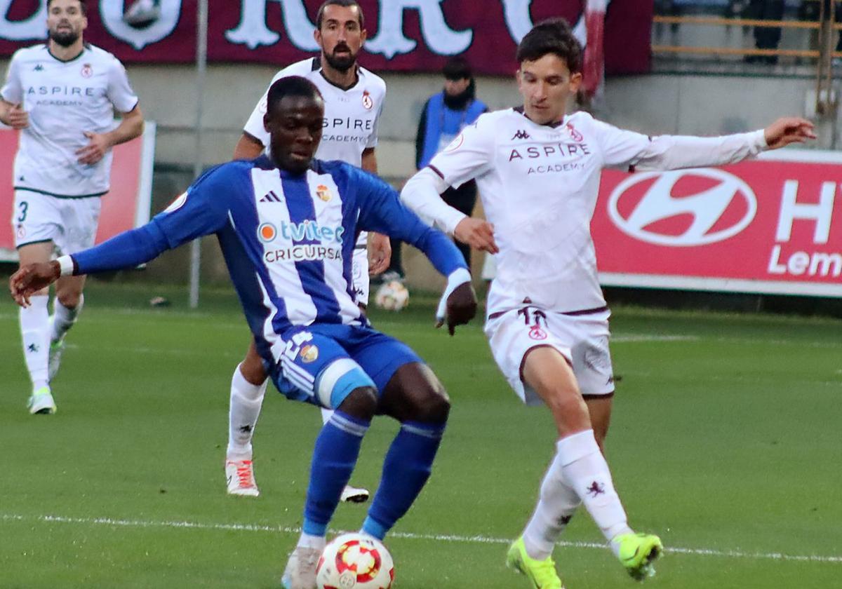 Luis Chacón, jugador de la Cultural, y Doué, jugador de la Deportiva, en un lance en el derbi de los dos equipos leoneses.