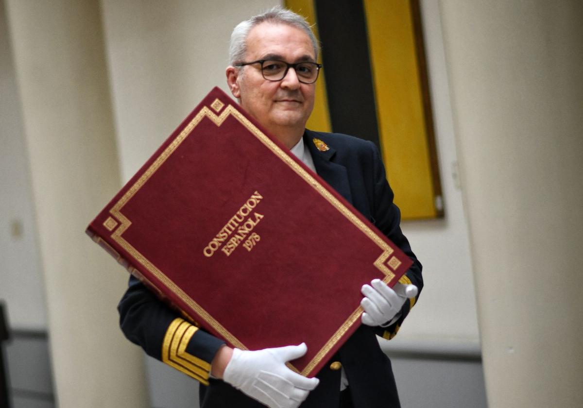 Un hombre carga una copia de la Constitución Española en el Senado