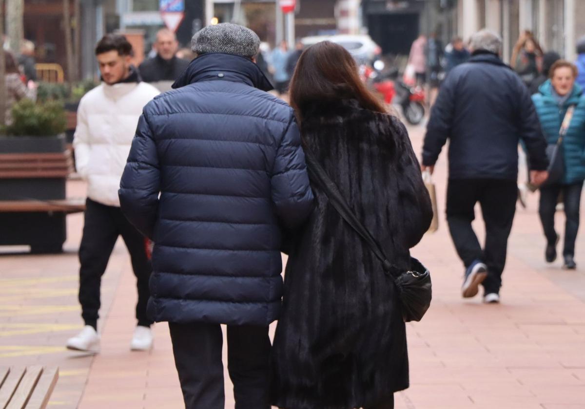 Dos ciudadanos leoneses caminan por las calles de León.