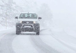 Imagen de archivode un coche circulando con nieve.