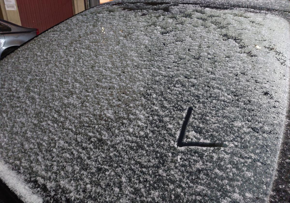 Una 'L' dibujada sobre la luna de un coche cubierto con una finísima capa de nieve.