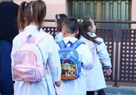 Una fila de niños el primer día de colegio.