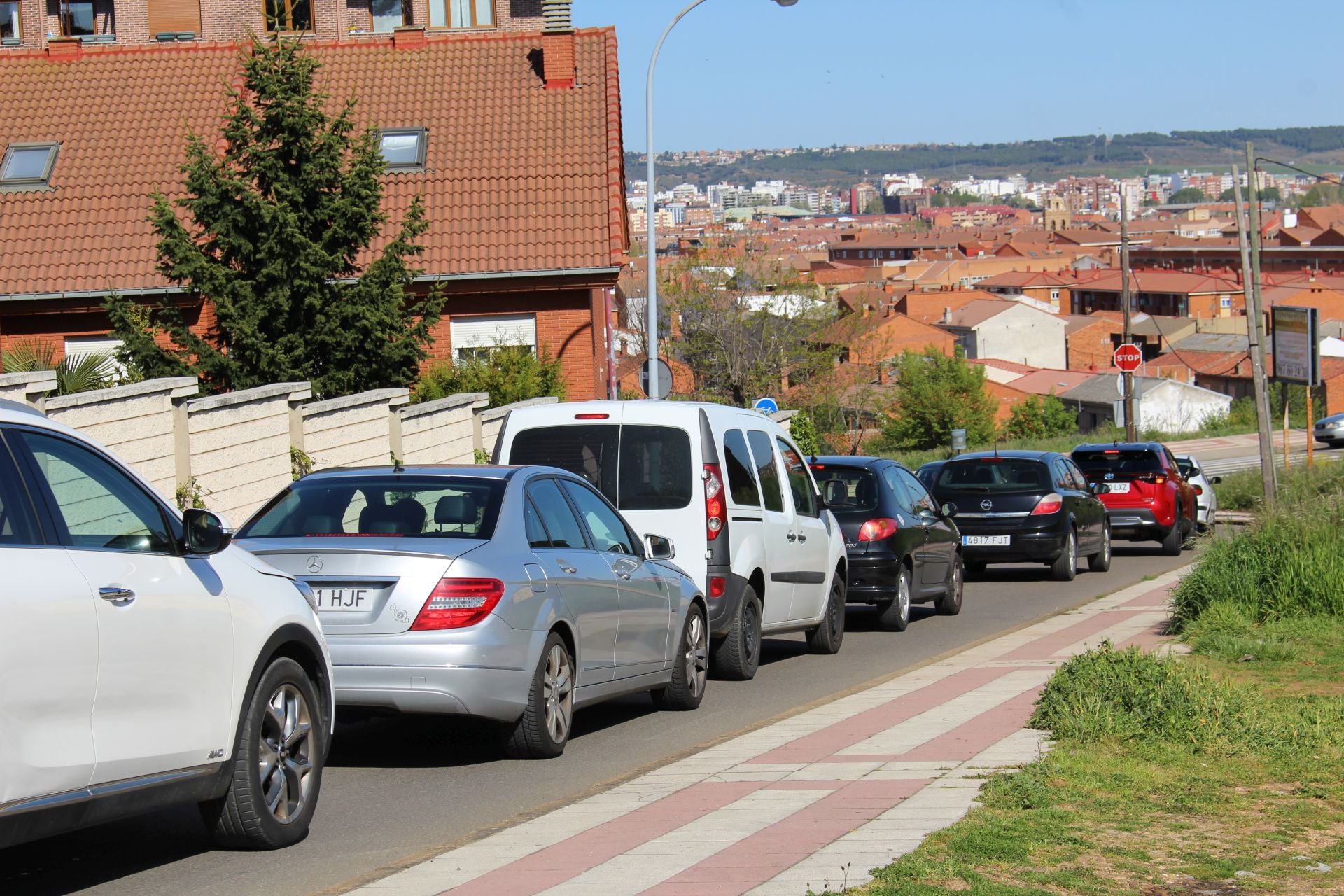 Fila de coches para acceder a la avenida del Párroco Pablo Díez desde el Camino la Cruz.