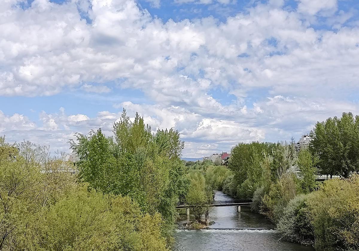 Cielo lleno de nubes visto un puente sobre el río Bernesga en León.