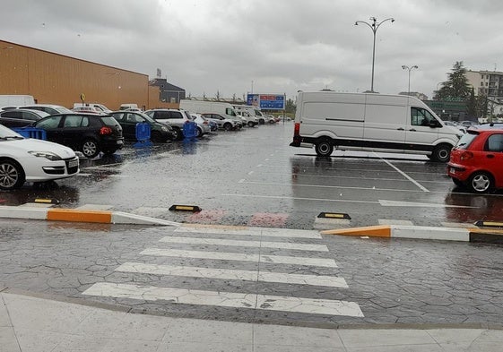 Un aparcamiento de un centro comercial en León encharcado durante una tormenta.