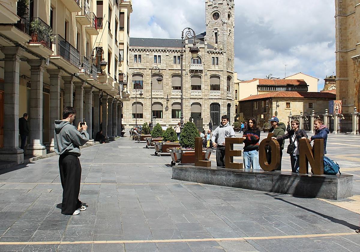 Un grupo de turistas disfrutan del tiempo soleado en la plaza de Regla de León.