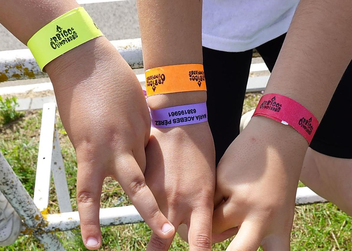 Imagen secundaria 1 - Momento previo a una carrera, las pulseras de los participantes y las medallas para los ganadores en las II OrbigOlimpiadas.