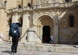 Una peregrina del Camino de Santiago en su etapa por León se para frente a San Isidoro.