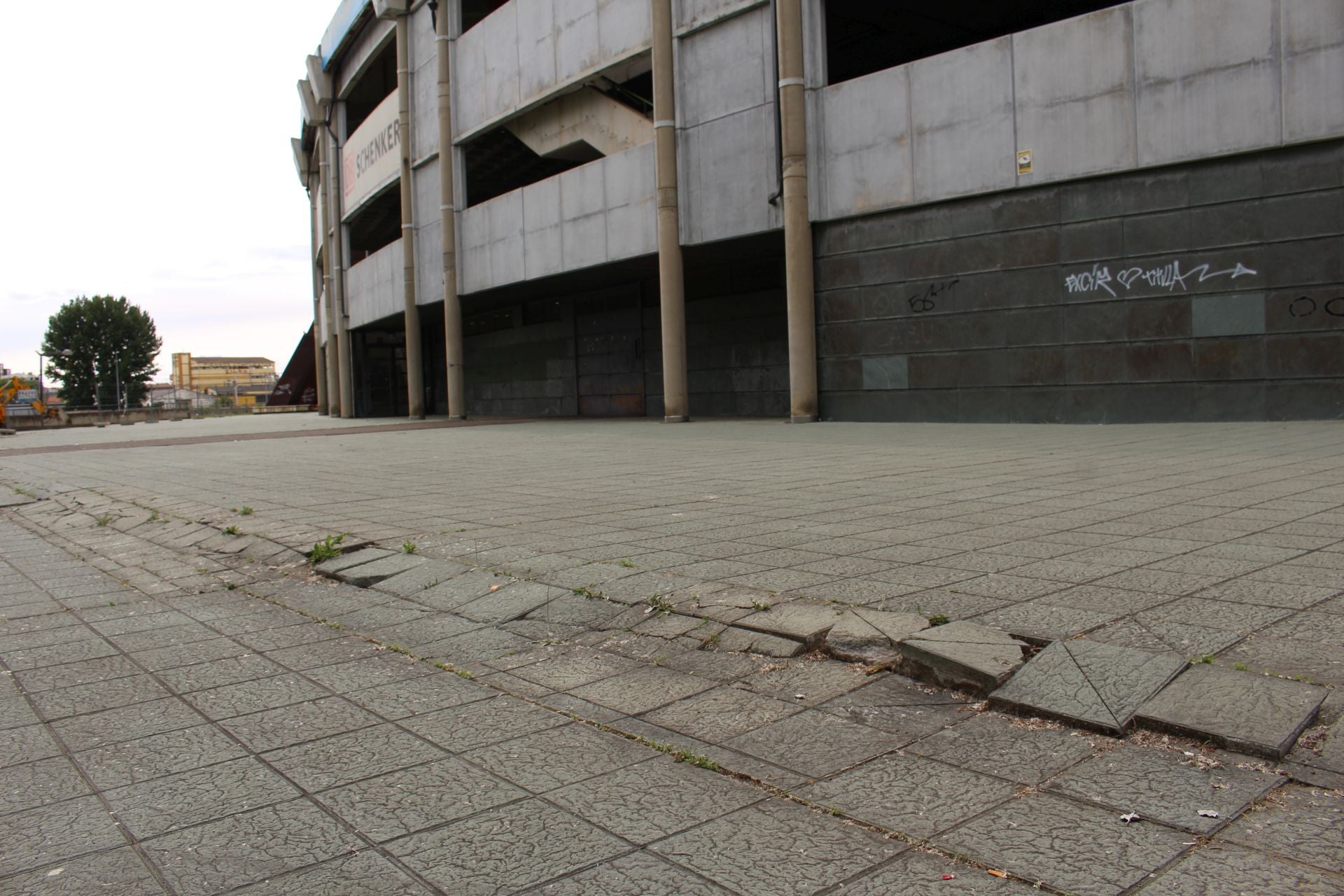 Imagen secundaria 1 - Baldodas levantadas y rotas en las explanadas que rodean al estadio Reino de León.