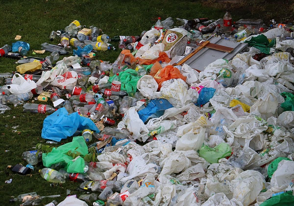 Imagen principal - La lluvia no ahoga el macrobotellón de la noche de San Juan a orillas del Bernesga
