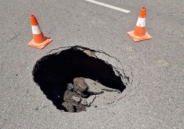 Un boquete en mitad de la calzada corta el tráfico en una calle de León
