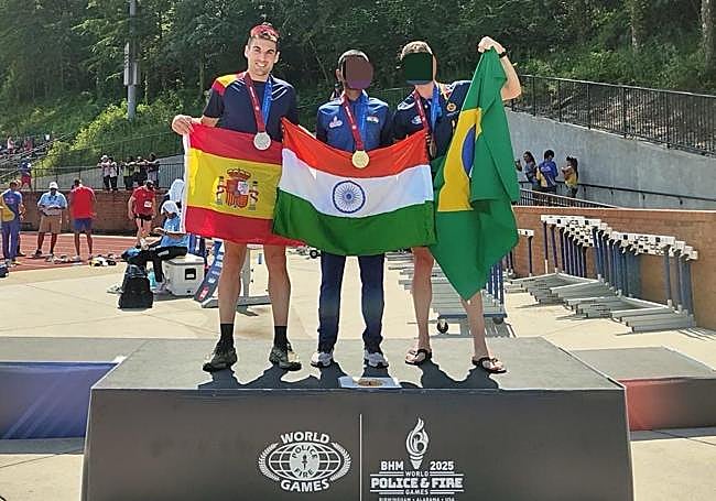 Javier Coria en el podio tras ganar la plata en los 10.000 metros pista junto a otros dos corredores.
