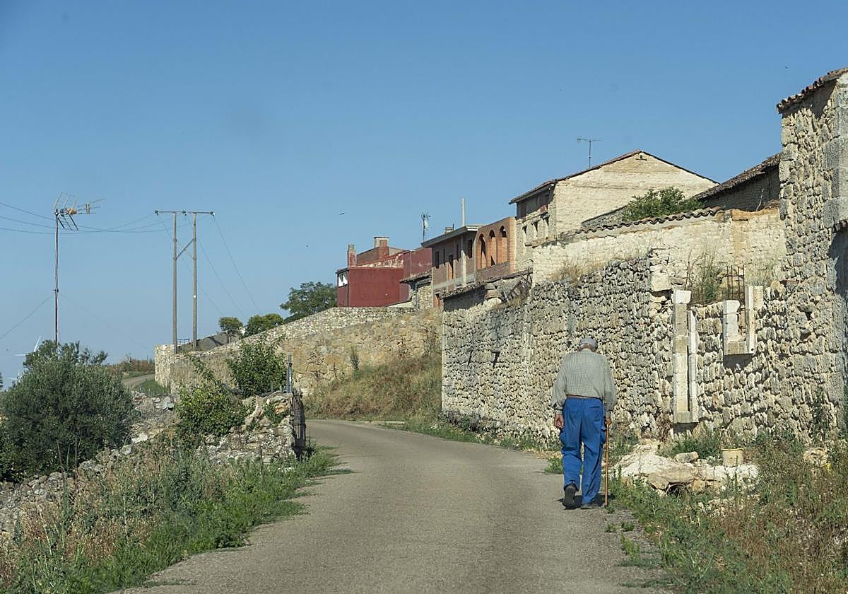 Un hombre pasea por las calles de su pueblo.