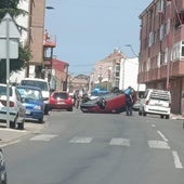 Un coche volcado corta un carril en una calle de Trobajo del Camino.