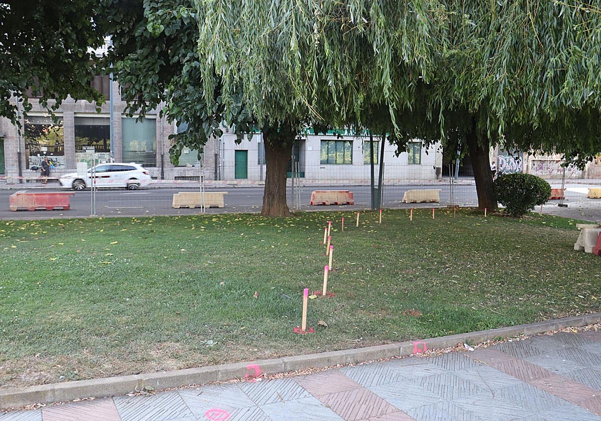 Imagen principal - Estacas, vallado y pintura rosa y verde marcan la zona ajardinada y acera que desaparecerá para dejar espacio a la futura rotonda junto al Puente de los Leones.