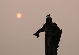 El sol enrojecido en la tarde del lunes 18 de agosto tras la estatua de Guzmán el Bueno en León.