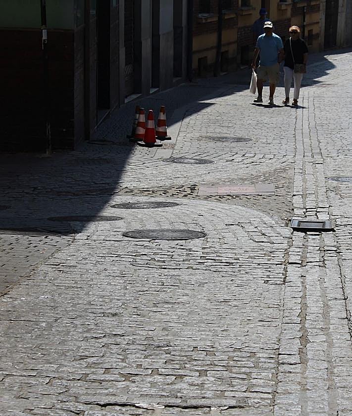 Imagen secundaria 2 - Baches, tramos hundidos y ausencia de adoquines en la calle Santa Cruz.