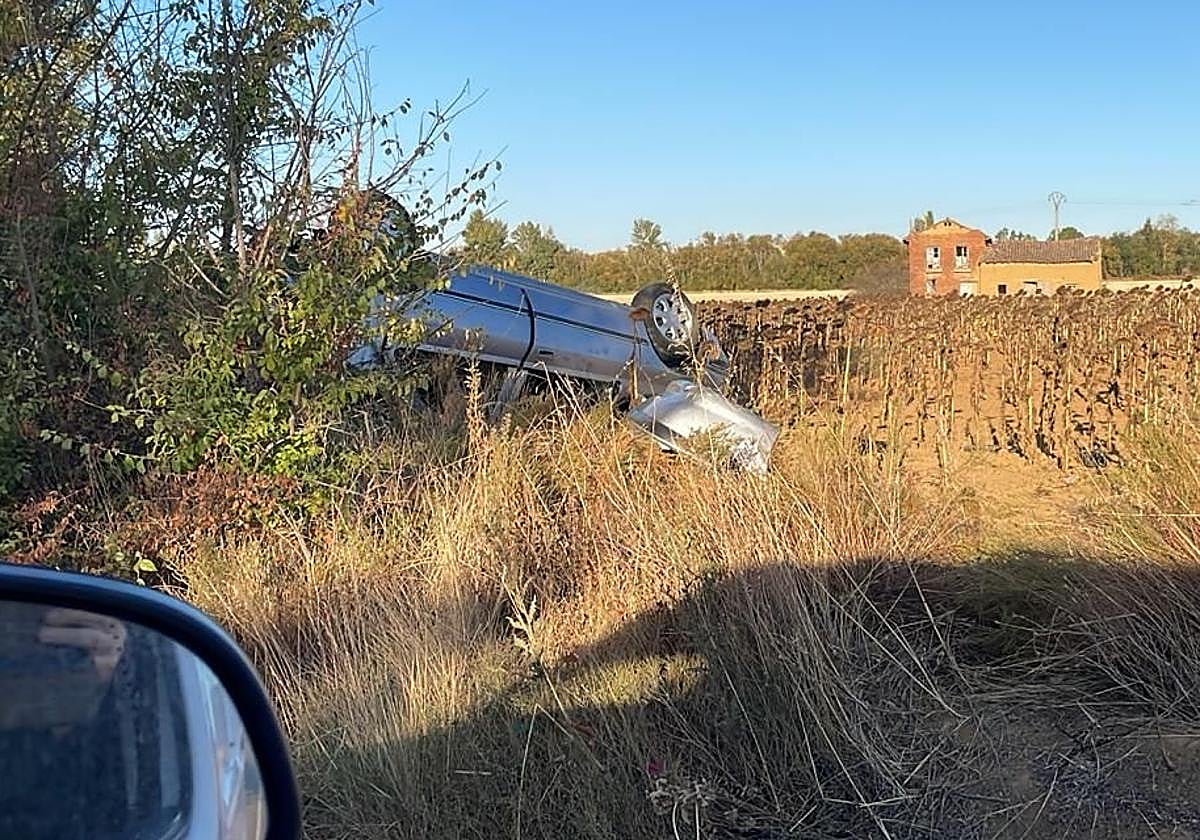 El coche volcado en la entrada del pueblo.