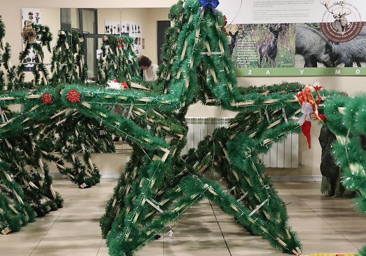 Imagen principal - Nuevas decoraciones y vecinos de Almanza trabajando en la casa de la cultura. 