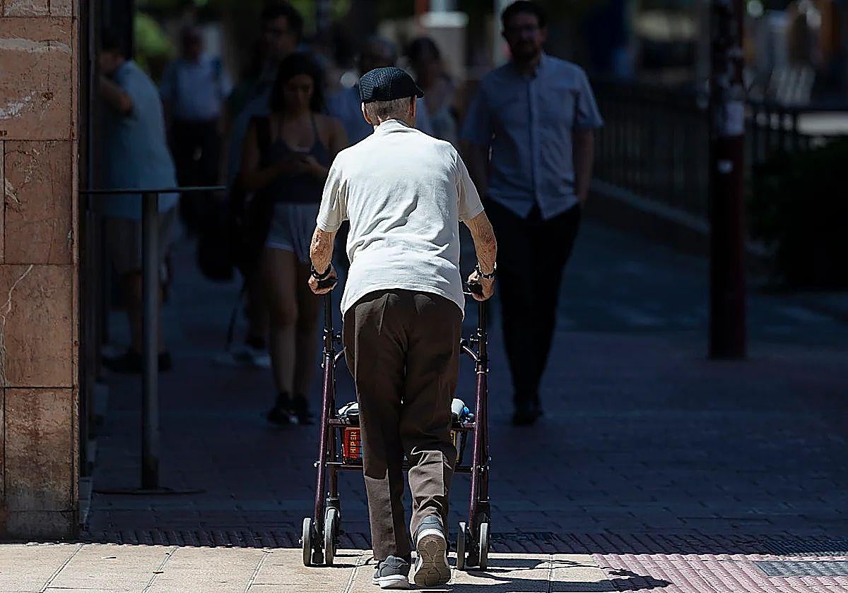 Una persona mayor camina con su andador por la calle en Valladolid.
