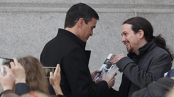 Momento en el que Iglesias regala un libro a Sánchez antes de su reunión. 