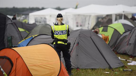 Una policía permanece en guardia en la zona de acampada del festival de música de Bravalla en Norrkoping.