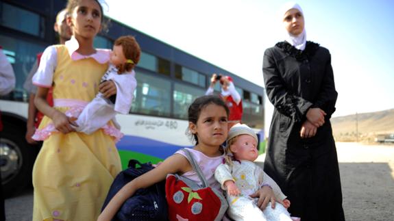 Dos niñas llegan a un campo de refugiados en Damasco. 