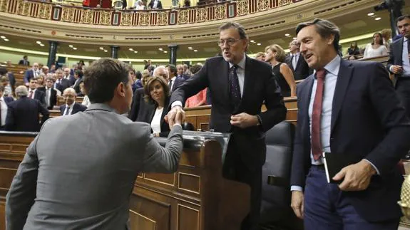 El presidente de Ciudadanos, Albert Rivera (i) saluda al candidato a la presidencia del Gobierno, Mariano Rajoy (c).
