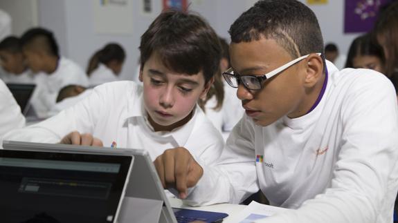 Dos niños aprenden conceptos básicos de programación e informática.